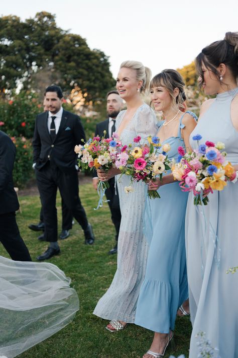 Kelsey & William's wedding at the Natural History Museum. Her bridesmaids were her "something blue" with their wildflower-inspired bouquets by Tularosa Flowers Blue Bridesmaid Dresses Bright Flowers, Dusty Blue Wedding With Wildflowers, Colorful Lake Wedding, Blue And Wildflower Wedding, Wildflower Wedding Bridesmaid Dresses, Blue Bridesmaids Colorful Flowers, Wildflower Bridesmaids Bouquet, Bridesmaids With Colorful Bouquets, Wildflower Bridal Party