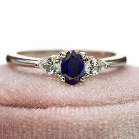 Elevate your engagement with the Tressa - Three Stone Prong Set Oval Lab Sapphire Engagement Ring, featuring a luxurious oval lab-grown blue sapphire as its centerpiece, surrounded by pear-shaped white sapphires on either side. Featuring 2 pear-shaped side white sapphires to frame a deep blue oval sapphire, this three-stone engagement ring embodies timeless beauty and attention to detail. Shop here: https://nodeform.com/products/tressa-three-stone-prong-set-oval-lab-sapphire-engagement-ring-w... Three Stone Sapphire Engagement Ring, Diamond And Sapphire Ring, Sapphire Wedding Band, Sapphire Band, Stunning Engagement Ring, Sapphire Engagement Ring, Three Stone Engagement Rings, Silver Engagement Rings, Detail Shop