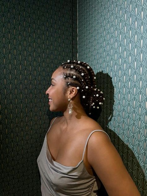 Looking for a fresh and vibrant take on the timeless cornrow style? Discover new ways to spice up cornrow hairstyles that are guaranteed to make a statement! From unique partings to eye-catching accessories and intricate designs, we've got you covered!#CornrowCraze #BraidIdeas #HairInspo #AfricanBraids #NaturalHairTrends Pearls In Braided Hair, Pearls In Afro Hair, Pearl Hairstyles Black Women, Pearls In Braids, Locs With Pearls, Pearls In Hair Black Woman, Up Cornrow Hairstyles, Prom Hairstyles With Pearls, Afrocentric Braids