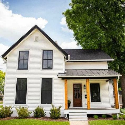 Charming 1900 renovated white urban farmhouse exterior in Beloit, WI with black windows, wood porch columns, and natural wood accents. Urban Farmhouse Exterior, White House Black Windows, 1900 Farmhouse, Urban Farmhouse Style, White Farmhouse Exterior, Farmhouse Addition, Siding Ideas, Farmhouse Stools, White Exterior Houses