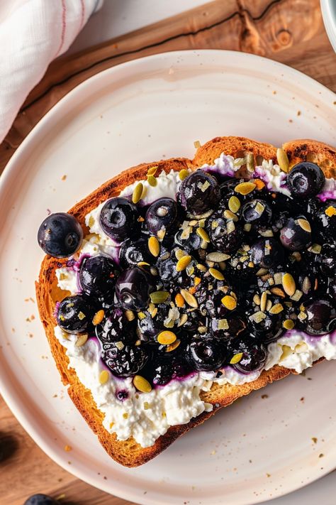 Indulge in a guilt-free and delicious breakfast with our Cottage Cheese Blueberry Toast, made effortlessly in the air fryer. This recipe combines the creaminess of cottage cheese with the sweetness of blueberries on crispy toast for a perfect morning treat. Whether you're looking for a quick breakfast or a healthy snack, this dish is sure to satisfy your cravings while keeping you energized throughout the day. Treat yourself to a delightful meal that's easy to make and full of flavor!  Ingredien Air Fryer Cottage Cheese Toast, Toast With Cottage Cheese, Blueberry Cottage Cheese, Cheese Air Fryer, Cottage Breakfast, Air Fryer Blueberry, Cottage Cheese Toast, Blueberry Toast, Low Calorie Pancakes