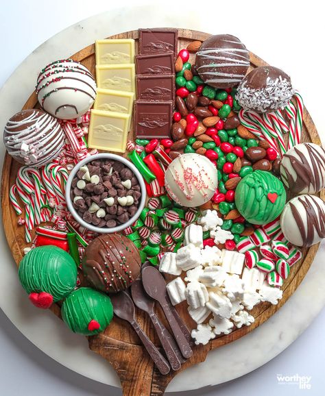 round grazing board filled with candy and hot cocoa bombs Christmas Charcuterie Board Hot Coco, Christmas Hangout, Oreo Truffles Christmas, Hot Cocoa Charcuterie Board, Hot Cocoa Board, Hot Chocolate Board, Cocoa Board, Sweet Charcuterie, Charcuterie Christmas