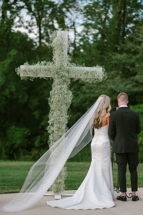 This was the epitome of a classic, southern, summertime wedding. A few rain drops, a lot of sun, a few happy tears, and a LOT of fun! This couple celebrated their classic, romantic wedding at the Commonwealth Event Center of Paducah, Kentucky. The wedding color palette was a classic black and white, with the bridal party wearing black, florals were white, mainly white roses and baby’s breath. A symbolic cross of solely baby’s breath was a magnificent ceremony centerpiece not to be missed. Cross Aisle Wedding, Ceremony Cross Wedding, Cross At Wedding Ceremony, Cross Ceremony Wedding, Flower Cross Wedding Altars, Flower Cross Wedding, Cross Wedding Ceremony, Alter Wedding, Cross Flowers Wedding