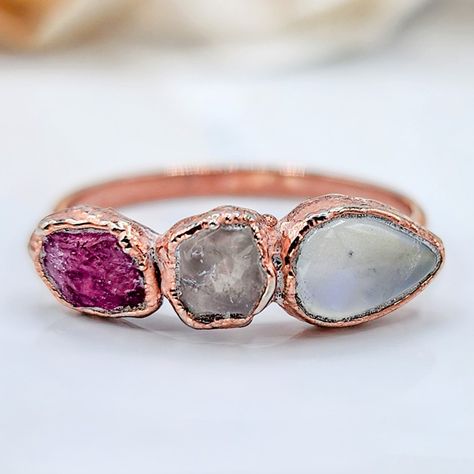 The photos truly do not do this ring justice. ♡ Raw Pink Sapphire, Raw Rose Quartz, and Pear-shaped Moonstone Ring This stunning rose gold ring features a mesmerizing moonstone matched with the delicate allure of a raw pink sapphire and rose quartz. The blend of these natural gemstones creates a harmonious fusion of soft pink hues and celestial brilliance. The rose gold setting enhances the overall rugged elegance, making it a unique and enchanting piece of jewelry. #sapphirering #pink... Birthstone Jewelry Mothers, Raw Diamond Rings, Raw Crystal Ring, Raw Gemstone Ring, Raw Stone Ring, Raw Rose Quartz, Pink Sapphire Ring, Rose Quartz Ring, Raw Diamond