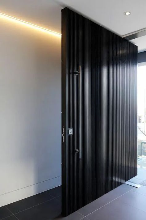 a super elegant black wooden slab door with a large metal handle is a cool and bold idea for a minimalist or conteporary home Pintu Interior, Modern Entrance Door, Contemporary Front Doors, Main Entrance Door Design, Pivot Door, Gate Locks, Entrance Gates Design, Contemporary Doors, Modern Entrance