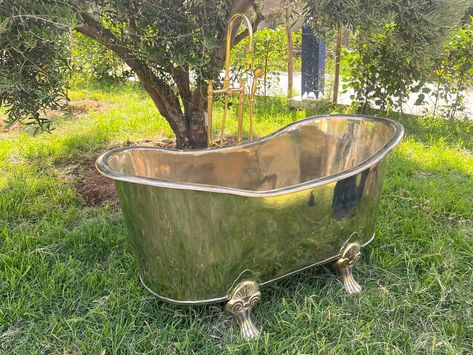 Indulge in the timeless elegance of our Antique Brass Freestanding Bathtub. Handcrafted from luxurious solid brass and adorned with classic clawfeet, this vintage-inspired bathtub is the epitome of opulence and relaxation. Transform your bathroom into a sanctuary with this stunning centerpiece. Customization: - Tailor this bathtub to your unique space! We offer customization options to ensure a perfect fit. - Choose from a variety of finishes to complement your decor: Copper, Nickel, or Matte Black. - Hole size can also be customized to your specifications. - Please Contact us for more details about size Details: - Material: Solid Brass - Design: Traditional, Vintage-inspired - Inside Size: 66 inches x 26 inches x 24 inches - Outside Size: 70 inches x 31 inches x 30 inches - Weight: 50 - 6 Stock Tank Tub Bathtubs, Bathtub Vintage, Bathroom Centerpiece, Vintage Clawfoot Tub, Slipper Bathtub, Old Bathtub, Vintage Bathtub, Slipper Tubs, Drop In Sink