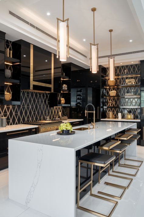 Luxurious modern kitchen with a large marble island, black cabinets, and gold accents. Black White And Gold Interior Design, Black Glam Kitchen, Black And Gold Kitchen Ideas, Black White And Gold Kitchen, Black White Kitchen Ideas, Black White And Gold Decor, Modern Elegant Kitchen, Gold Home Decor Ideas, Modern Gold Kitchen