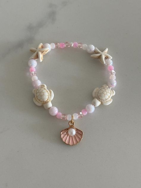 Pink Beach themed bracelet with turtle and starfish beads plus a shell charm with a pearl. Includes an assortment of beautiful light pink beads that looks like a sunset Mermaid Pearl Jewelry, Bracelet Beach Summer, Beach Theme Bracelets, Beaded Bracelets Beach, Sea Shell Bracelet Diy, Clay Bead Bracelet Pink, Beachy Clay Bead Bracelet, Beach Bracelet Ideas, Bracelet Inspi