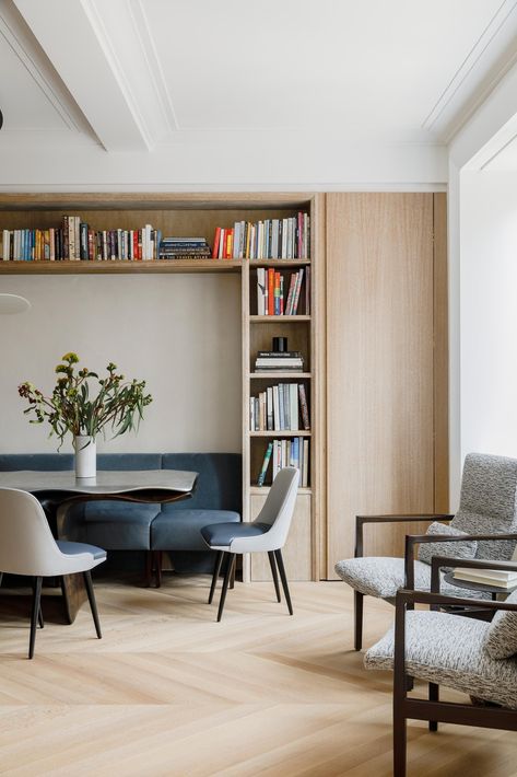 Within this dining room, chairs fit perfectly within the surrounding millwork, allowing them to act as a bench or break apart into chairs. Built In Bench In Dining Room, Narrow Dining Cabinet, Dining Room Banquette Bookshelves, Under Window Bench Dining Room, Dining Bench And Chairs, Dining Bench Between Cabinets, Storage Dinning Room, Dining And Study Combo, Dining Room Study Area