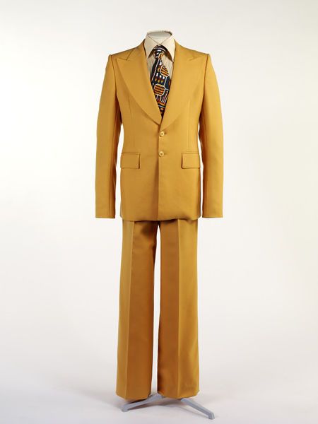 Man's suit | Victor Herbert | Great Britain, United Kingdom, 1974 | Material: wool | Herbert uses traditional tailoring techniques combined with flamboyant details of cut and colour typical of 1970's British menswear | VA Museum, London Colourful Suit, 70s Fits, 70s Suit, Theater Poster, Retro Suits, 70s Men, Fashion 1970s, Yellow Suit, That Dress