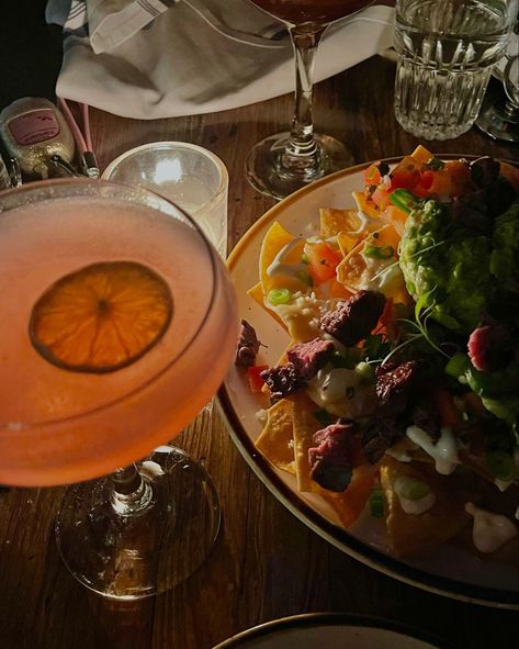 Picture of pink cosmopolitan cocktail and steak nachos in dim lighting. Nachos Aesthetic, Going Out Aesthetic, Steak Nachos, Cosmopolitan Cocktail, Out Aesthetic, Nyc Food, Nyc Restaurants, Nachos, Cosmopolitan