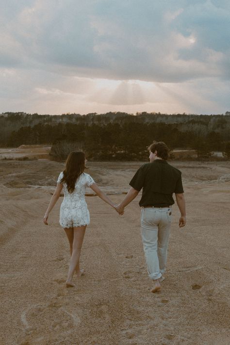 A vintage edit of a couple holding hands and walking in sand. #couplesphotoshoot #couplesphotography #engagementphotos #engagementphotoshoot #documentaryphoto #vintagephotography #sunsetphotography Holding Hands From Behind, Couples Holding Hands Walking, Couple Walking Photo, Couple Walking Holding Hands, Cottagecore Couple, Rachel Tattoo, Two People Holding Hands, Parallel Play, Holding Hands Walking