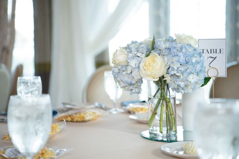 Classic Wedding Reception Decor, Low Floral Centerpiece and Table Number, with Dusty Blue Hydrangeas, Ivory Rose Floral Arrangement in Glass Vase | Tampa Bay Luxury Wedding Planner Coastal Coordinating Small Blue And White Floral Centerpieces, Classic Wedding Reception Decor, Distressed Vase, Practical Wedding Gifts, Boho Wedding Colors, St Pete Wedding, Rose Floral Arrangements, Blue Centerpieces, Sunflower Themed Wedding