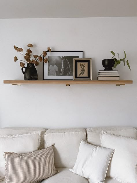 Simple Living Room Shelf Decor, Large Living Room Shelf, Floating Shelf Above Credenza, Floating Mantle Above Couch, Practical Shelf Styling, Floating Shelf Wall Sconces, Two Shelves Above Couch, Wood Shelf Over Bed, Long Ledge Shelf