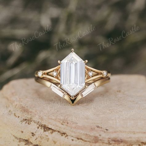 Unique Hexagon Cut Moissanite Engagement Ring Set Solid Gold Baguette Cut Wedding Band Promise Bridal Ring Set Anniversary Gift For Her ITEM DETAILS ●Available in yellow, white or rose solid 10k, 14k or 18k gold. This ring can be made in Platinum, Sterling silver, Gold plated. ❀❀Center Stone: Moissanite Shape: Long hexagon cut Size: 6x11 mm Clarity - SI-VS Color- G-H Side stones: Moissanite Shape: Round cut Weight: about 0.4ct Clarity - SI-VS Color- G-H Band width: Around 1.5mm ❀❀Wedding band Stones: Moissanite Shape: Baguette shape Weight: about 0.192ct Clarity - SI-VS Color- G-H Band width: Around 1.3mm Visit my shop for more jewelry: https://www.etsy.com/shop/TheRoseCastle ❀Production ---- This ring is handmade and very good quality! Please allow 2-4 weeks for production. It can be made Unique Promise Rings For Her Gold, Emerald Cut Art Deco Ring, Hexagon Engagement Rings, Kite Cut Engagement Ring, Hexagon Engagement Ring, Moissanite Engagement Ring Set, Cute Engagement Rings, Future Engagement Rings, Engagement Ring Shapes