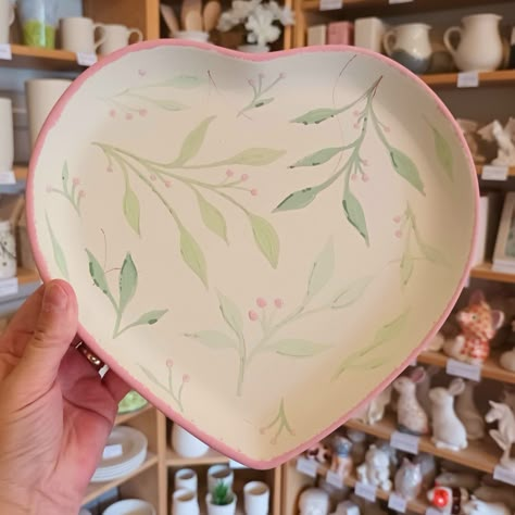 Green leaves and red berries on a heart plate, before firing, pottery painting Pottery Painting Ideas Leaves, Valentine Pottery Painting Ideas, Heart Pottery Painting Ideas, Anniversary Pottery Painting, Pottery Painting Heart Plate, Heart Plate Painting, Heart Bowl Pottery Painting, Pottery Painting Hearts, Heart Plate Pottery Painting