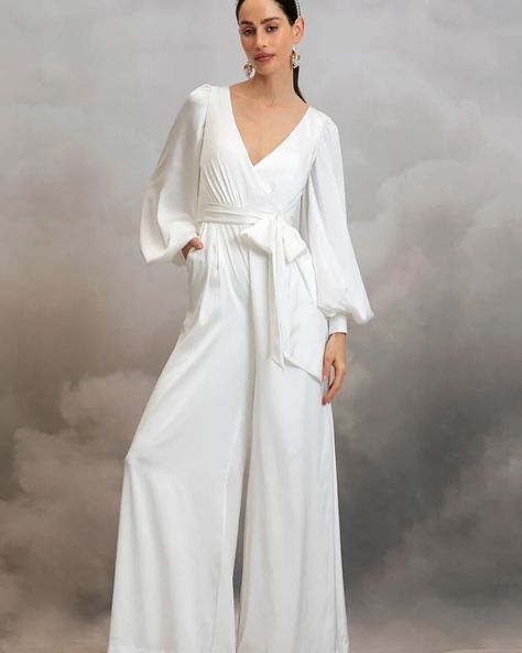 MIA JUMPSUIT by @catherine__deane — The Mia Jumpsuit is cut from luxurious eco satin. This classic bridal jumpsuit features a crossover, low V-front neckline, low V-back and long bishop sleeves with statement cuffs. Mia’s detachable waist sash cinches in the small of the waist for a figure flattering silhouette and her comfortable, wide leg trousers will see you dancing the night away in effortless ease! #bridalwear #bridaljumpsuit #jumpsuit #civilwedding #civilweddingdress #standesamt #we... Vietnam Clothes, Unusual Wedding Dresses, Tuxedo Jumpsuit, Wedding Dress Types, Catherine Deane, Bridal Kimono, Designer Wedding Shoes, Wheel Of Time, Sleeved Wedding