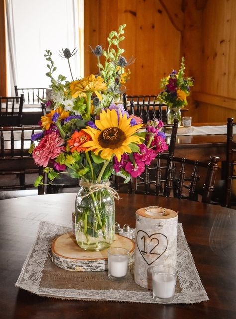 we love these country wildflower centerpieces featuring sunflowers, stock, zinnias and thistle in mason jars.  Designed by Jen-Mor Florist in Dover, Delaware. www.jenmor.com Summer Arrangements, Wild Flower Wedding, Wildflower Centerpieces, Farm Flowers, Bohemian Weddings, Sunflower Arrangements, Wedding Motifs, Boda Mexicana, School Theme