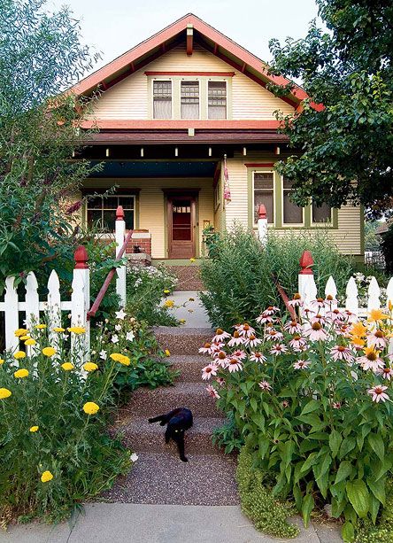 A bungalow front garden with picket fence and a profusion of daylilies, and purple coneflower shows great curb appeal. Bungalow Landscaping, Craftsman Landscaping, Arts And Crafts Bungalow, Picket Fences, Bungalow Exterior, Craftsman Exterior, Bungalow Homes, Cottages And Bungalows, Craftsman Style House