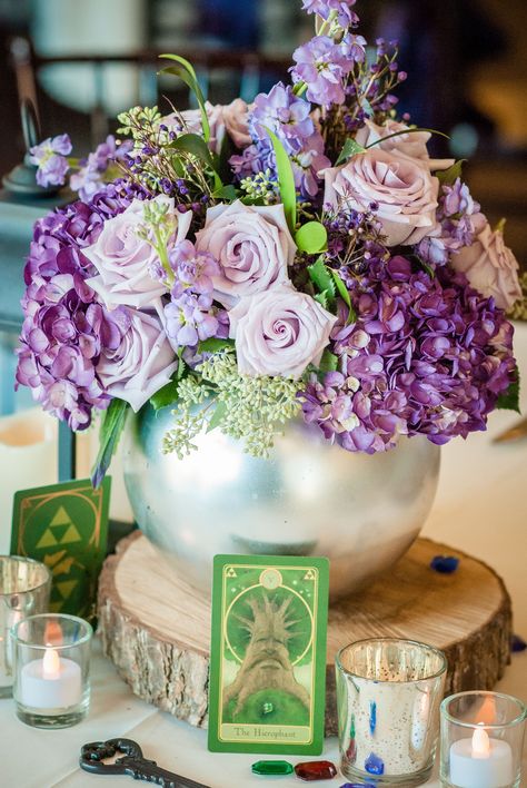 My Mother-in-Law created some amazing centerpieces. Most were variations of the same design: wood plank bases, mercury glass candle holders (with LED candles), a sprinkling of plastic rupees, Zelda-themed tarot cards, iron keys, and a vase with flowers. Zelda Themed Wedding, Card Box Diy, Constellation Wedding, Video Game Wedding, Zelda Party, Zelda Wedding, Gamer Wedding, Nerd Wedding, Jasmine Wedding