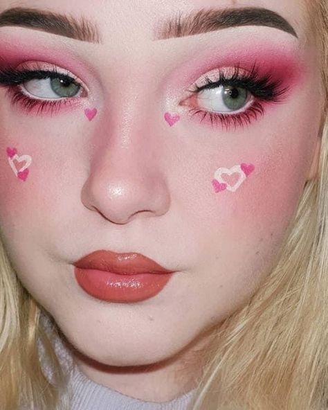 pink eyeshadow and a heart accent on the cheeks Pink Makeup Looks Hearts, Heart Pink Makeup, Hearts On Cheeks Makeup, Heart On Cheek Makeup, Cute Makeup Looks Aesthetic Pink, Graphic Face Makeup, Heart Cheek Makeup, Kawaii Pink Makeup, Pink Heart Eye Makeup