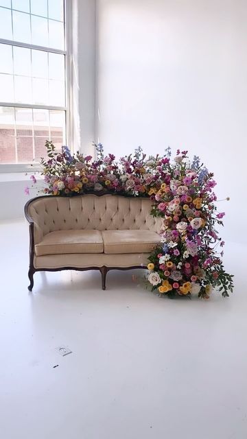 Sofa Flowers Wedding, Couch Photo Op Wedding, Sofa With Flowers Wedding, Floral Couch Photoshoot, Vintage Couch Backdrop, Couch Floral Installation, Wedding Expo Booth Ideas Floral Design, Vintage Couches Wedding, Flower Back Drop Photoshoot