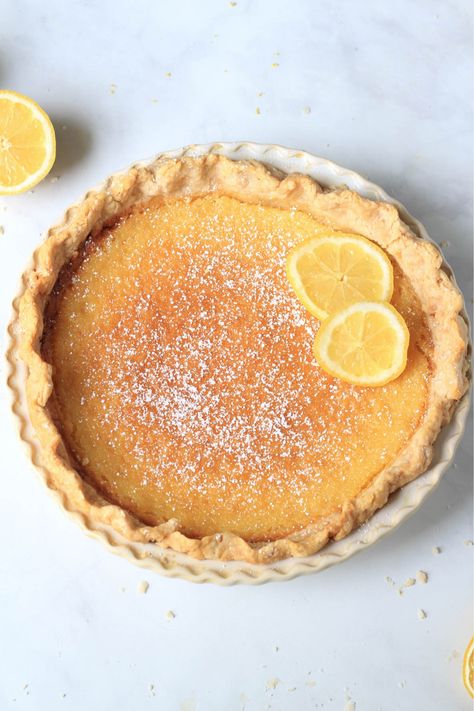 A flavorful twist on a classic dessert, this Lemon Chess Pie is your new go-to summer treat! This dairy-free delight is not your average pie recipe. Bursting with the tangy freshness of pure lemon, it promises to be a tantalizing addition to your dessert repertoire. So why wait? Get ready to roll out your pastry and squeeze some fresh lemons for an irresistible slice of summer! This easy lemon chess pie recipe pairs well with fresh vegan whipped topping or a dusting of powdered sugar. Lemon Chess Pie Recipe, Dairy Free Pies, Lemon Chess Pie, Non Dairy Desserts, Chess Pie Recipe, Lemon Pie Recipe, Pie Dough Recipe, Chess Pie, Lemon Dessert