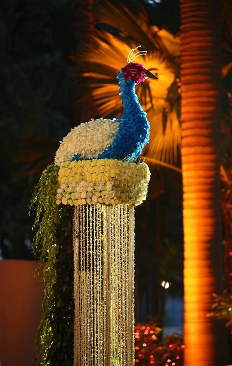 A gorgeous model of peacock made with flowers is adding a unique glamour to the wedding venue | wedding inspiration | wedfine.com | Peacock Theme Decor, Indian Wedding Decor, Wedding Hall Decorations, Peacock Theme, Mandap Decor, Desi Wedding Decor, Marriage Decoration, Mehndi Decor, Peacock Decor