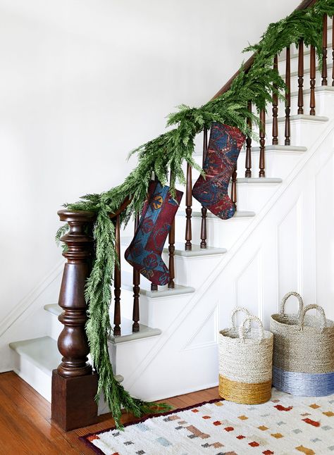 18 Modern Holiday Decoration We're Obsessed With | Deck whatever halls you have this season-these festive ideas will help you spruce up your space, and make holiday decorating stress-free.  Create a stockinged stairwell by hanging stockings from a banister trimmed with garland.  #holidaydecor #holidaydecorations #realsimple #christmas Stockings On Staircase, Staircase Decor Ideas, Christmas Staircase Decor, Glass Bowl Decor, Christmas Staircase, Modern Holiday Decor, Decor Color Schemes, Elegant Christmas Decor, Staircase Decor