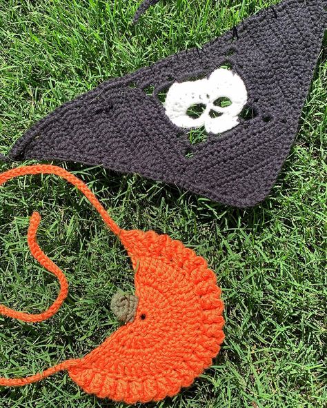 Crochet orange pumpkin and black and white skull pet bandanas laying out on the grass in the sun. Crochet Dog Bandana, Halloween Crochet Bandana, Crochet Dog Halloween Costume Free Pattern, Crochet Halloween Dog Bandana, Crochet Halloween Dog Costumes, Crochet Skull Bandana, Crochet Pet Halloween Costume, Knitting 101, Crochet Dog Clothes