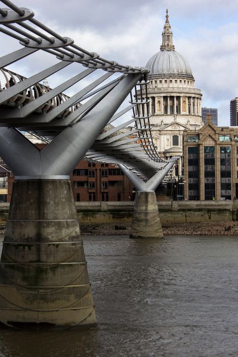 The Millennium Bridge, officially known as the London Millennium Footbridge, is a steel suspension bridge for pedestrians crossing the River Thames in London, linking Bankside with the City of London. It is owned and maintained by Bridge House Estates, a charitable trust overseen by the City of London Corporation. Construction began in 1998, and it initiallyopened in June 2000. Millennium Bridge London, Bridge House, Millennium Bridge, London Architecture, City Of London, Uk Destinations, Pedestrian Bridge, Suspension Bridge, River Thames