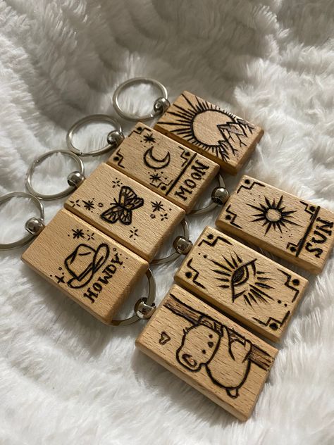 Cute and aesthetic handmade wood-burned keychains, varnished with danish oil for protection! 7 different options to choose from: Howdy cowboy hat, Butterfly, Moon and sun tarot cards, Mountain sunrise, cute koala tree hug, and a mystical eye version :) Wood Projects Aesthetic, Wood Burning Craft Ideas, Wood Burn Patterns, Best Selling Wood Projects Ideas, Personalized Laser Engraved Gifts, Wood Burn Designs Easy, Wood Burning For Kids, X Carve Projects, Wood Slice Ornament Burned