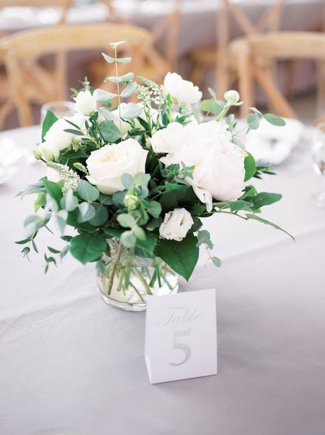 a fresh and stylish wedding centerpiece of various types of greenery, white peonies in a sheer vase is a lovely idea Elegant Wedding Shower Decorations, Table Flowers For Wedding, Small White Flower Centerpieces, Neutral Wedding Floral Arrangements, Elegant Wedding Centerpiece Ideas Round Tables, Small Centerpiece Wedding, Simple Wedding Florals, White Table Flowers, Elegant Wedding Centerpiece Ideas