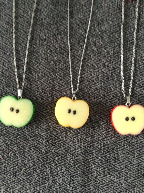 (1505)  Apple Slice Necklaces and Earrings.  Made with resin, about 1" x 1 1/4" Earrings on rhodium ear wires Necklaces on 18" stainless steel chain with extender and an apple charm A) Green Apple Slice Necklace w/ Charm and Earrings  B) Yellow Apple Slice Necklace w/ Charm and Earrings  C) Red Apple Slice Necklace w/ Charm and Earrings Apple Core Outfits, Cool Trinkets, Fruits Fashion, Clay Necklace Pendant, Apple Clothes, Apple Jewelry, Quirky Accessories, Apple Necklace, Apple Slice