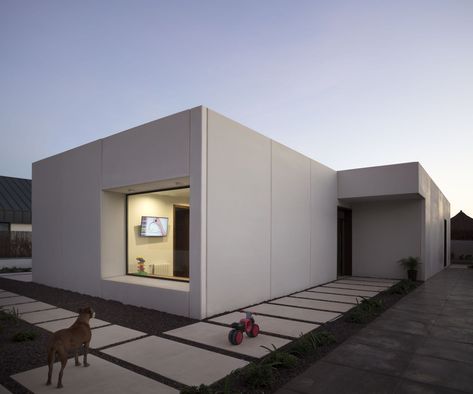 The project arises from a key premise set by clients, a young family with children. They were clear, they were looking for a functional home that was developed on the ground floor. From there, on a flat plot without large conditions, the simplicity and precision of the prefabricated concrete panels are sought to configure a house of pure lines and white color. Concrete House Interior, Small Concrete House, White Concrete House, Concrete House Design, Flat Roof Extension, Flat Roof House, Modular Housing, Modern Small House Design, Concrete Home