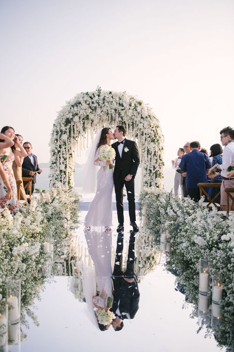 There are almost no words to describe this incredible destination wedding in Phuket. With a mirror walkway ending at a stunning white floral arch surrounded by the sea...these photos are out of this world! Reflective Walkway Wedding, Wedding Aisle Mirror, Mirror Ramp Walk Wedding, Mirrored Walkway Wedding, Mini Wedding Ceremony, Mirror Pathway Wedding, Mirror Isle Runner Wedding, All White Wedding Ceremony Decor, Mirror Isle For Wedding