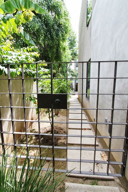 Square wrought iron gate. Kinda cool. But no landscaping on the other side. Low Gate Design, Modern Wrought Iron Fence, Diana Wong, Metal Side Gate, Wrought Iron Fences And Gates, Modern Iron Gate, Yard Gates, Iron Railings Outdoor, Porte In Ferro