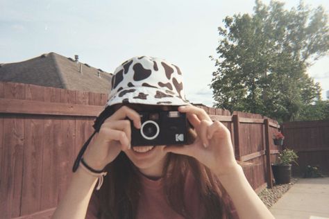 a girl holds up a black camera to her face and prepares to take a picture while wearing a cow print bucket hat Kodak M38 Pictures, Kodak M35, Analog Photography, 35mm Film, Photo Ideas, Film, Photography, Quick Saves