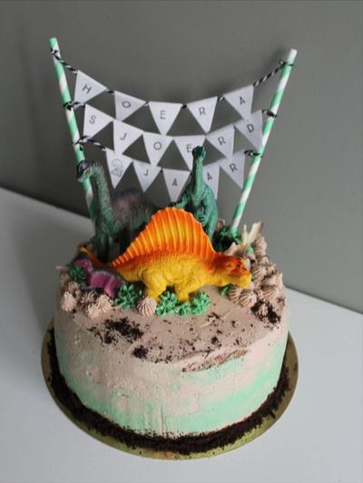 Een verjaardagstaart in dinosaurus thema. Gevuld met slagroom & aardbeienjam Cake