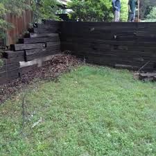 Why We Don't use Railroad Ties - Bailey Construction & Landscaping Railroad Tie Retaining Wall Landscaping, Railroad Tie Seating, Landscape Railroad Ties, Railroad Tie Retaining Wall Ideas, Railroad Ties Driveway Entrance, Railroad Tie Landscaping, Railroad Ties Landscaping Retaining Walls, Retaining Wall Railroad Ties, Retaining Wall With Railroad Ties