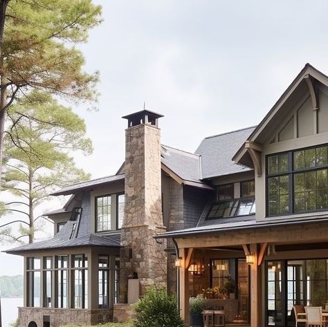 A grand luxury stone lake house with stone, siding, and detailed wood elements. A perfect blend of modern ranch and modern farmhouse style with black windows surrounded by beautiful outdoor living and gardens. Design: @windthekey Follow @windthekey for more design inspiration. Pacific Northwest Waterfront Home, Oregon Lake House, Craftsman Lake House Interior, Lake House Walkout Basement, Western Lake House, Colorado Lake House, Stone Lake House, Lake House Entryway Ideas, Lake House Exterior Colors