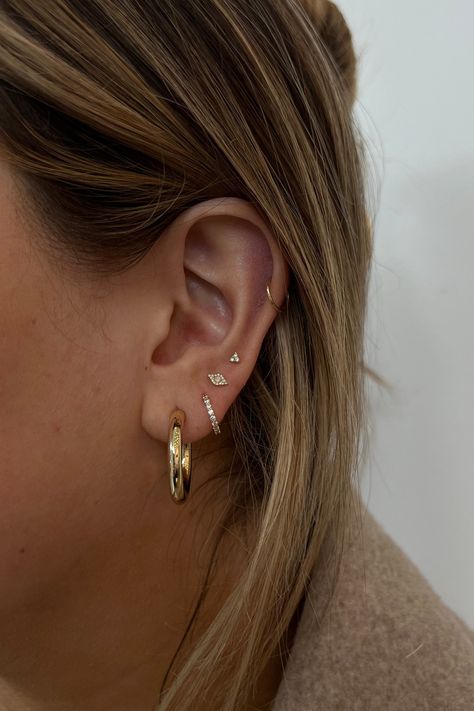 Have fun creating an ear stack you'll love. From solid gold hoops, diamond huggies and studs these earrings are designed to wear daily. Hoop Sizes On Ear, Small Ear Stack, Simple Ear Stack, Eating Stack, Minimalist Ear Piercings, Earring Stack, Ear Art, Cool Ear Piercings, Pretty Ear Piercings