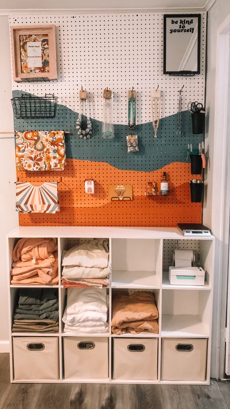 Small business packing station peg board with tee shirts Cricut Business Aesthetic, Boutique Clothing Storage, Peg Board Tshirt Display, Boutique Shipping Station, Home Office Packing Station, Local Store Aesthetic, She Shed Ideas For Small Business, Cute Peg Board Ideas, Retro Small Business