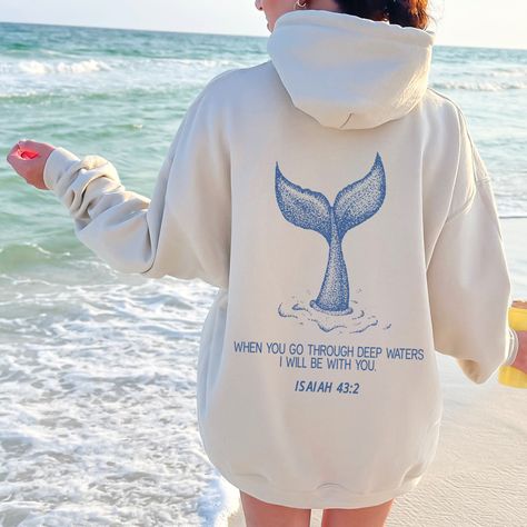 Dive into comfort and faith with our ocean inspired Isaiah 43:2 hoodie! With serene beach vibes & majestic whale motifs, this beachy bible verse hoodie is a testament to God's protection.. 🐋🌊 Perfect for devout Christians seeking comfort & style. Gift it to inspire loved ones! Order yours today!                                 ＊ 𝐍𝐎𝐓 𝐀𝐕𝐀𝐈𝐋𝐀𝐁𝐋𝐄 𝐈𝐍 𝐒𝐓𝐎𝐑𝐄𝐒 ＊ 👚 GET TO KNOW YOUR  WHEN YOU GO THROUGH DEEP WATERS HOODIE This When You Go Through Deep Waters Hoodie is printed on a Gildan 18500 Unisex Heavy Blend Hoodie with ink using a direct-to-garment printer. They will print your item and send it right to your door!  ✽ 50% Cotton 50% Polyster  ✽ Medium-heavy fabric (8.0 oz/yd² (271.25 g/m  ✽ Classic fit tubular body  ✽ Unisex Sizing  ✽ Runs True to size ◄ 𝗦 𝗜 𝗭 𝗜 𝗡 𝗚 Ocean Clothing Aesthetic, Cute Hoodies For Women, Christian Hoodie Design, God Hoodies, Beachy Clothes, Isaiah 43 2, Christian Clothes, Cute Hoodies, Beach Hoodie