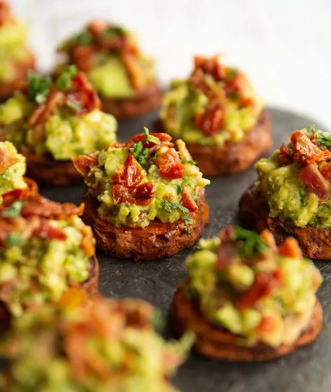 These mini sweet potato bites are served with a bacon and sun dried tomato guacamole. They're easy to make, perfect for a party and BURSTING with flavour! #guac #bacon #sweetpotato #fingerfood #appetizer | www.dontgobaconmyheart.co.uk Potato Nibbles Recipe, Sweet Potato Canapes, Sweet Canapes, Finger Food For Party, Hangover Brunch, Christmas Tapas, New Year Appetizers, Healthy Finger Food, Sweet Potato Appetizers