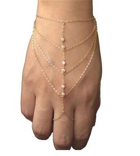 Hip and trendy, yet feminine! This body jewelry bracelet features 2 gold chains that wrap around the wrist and finger. Connecting them are 4 additional chains Jóias Body Chains, Hand Harness, Finger Bracelets, Hand Chain Bracelet, Diamond Bangles Bracelet, Tassel Bracelet, Hand Bracelet, Jewelry Model, Crystal Chain