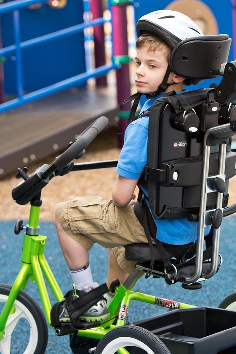 A boy wearing a helmet in a lime green Rifton Adaptive Tricycle Adaptive Bikes, Student Wellness, Gait Training, Wheelchairs Design, Gross Motor Activity, Pediatric Physical Therapy, Vision Therapy, Power Training, Muscular Endurance