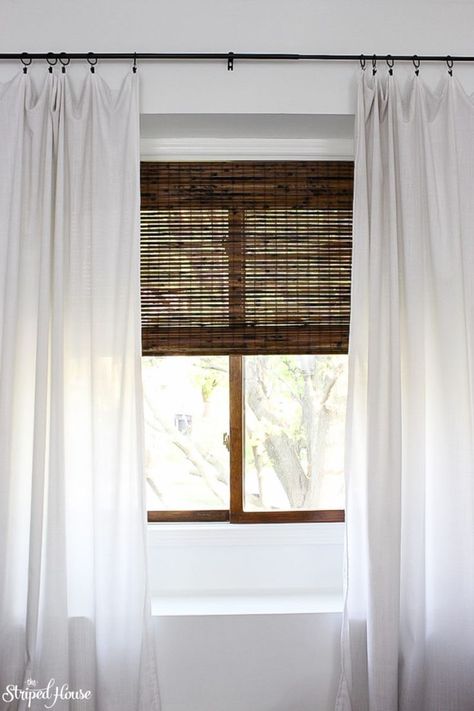 window makeover with bamboo blinds, white curtains and classic black curtain rod #traditionaldecor #interiordesign #homedecorideas #oneroomchallenge #myhousebeautiful #livingroom #decor #windowtreatment Bamboo Blinds Dark, White Curtains With Bamboo Shades, Wooden Blinds With Sheer Curtains, Bamboo Blinds And Curtains, White Bamboo Blinds, Dark Bamboo Blinds, Staining Bamboo Blinds, Bamboo Shades With White Curtains, Bamboo Blinds With Curtains Living Room