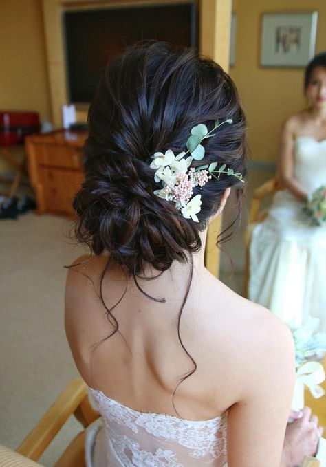 Hairstyles Low Bun Wedding, Flower In Bun Hair, Low Messy Bun With Flowers, Bridal Updo Brunette Low Buns, Low Bun Accessories, Quince Bun Hairstyles With Flowers, Hair Buns With Saree, Side Bun With Flowers, Low Bun Prom Hairstyles Brown Hair