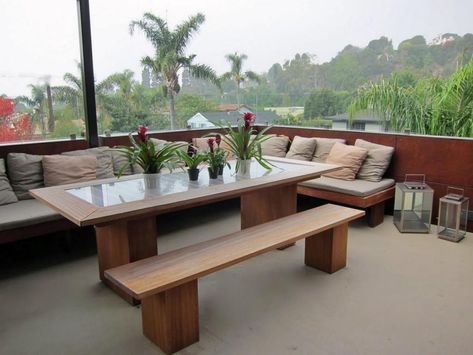 A built-in bench with ample pillows lines the wall of this outdoor dining area with a panoramic view. Build Outdoor Bench, Banquette Restaurant, Deck Seating Area, Modern Bench Outdoor, Corner Bench Seating, Outdoor Bench Seating, Deck Seating, Deck Dining, Outdoor Storage Bench